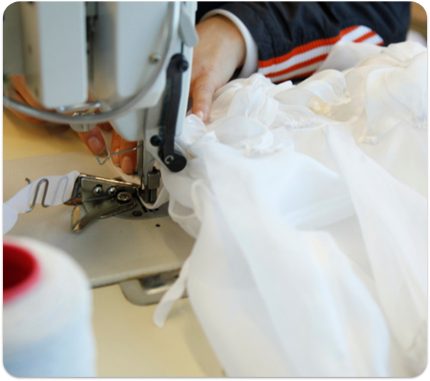 Seamstress stitching fabric on an industrial sewing machine, at Mirage, Vratsa.
