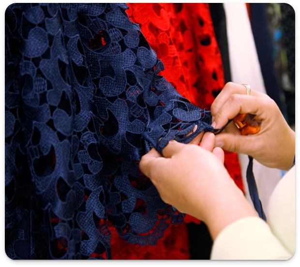 Sewing technologist examining lace fabric style dress sample at Mirage, Vratsa.