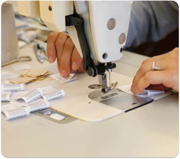 An employee prepares garment labelling