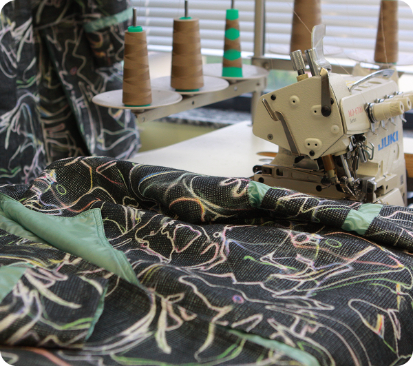 Close-up of Ladies stylish coat draped across sewing desk at Mode Agency Mirage